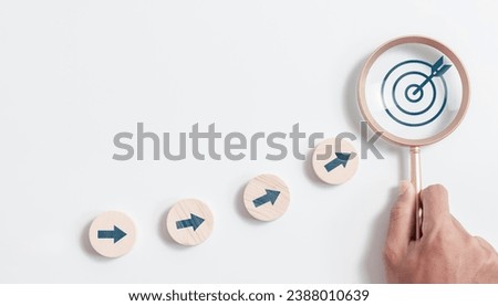 Circle wooden block with arrow aim to target and Magnifying glass focus to goal icon. business strategy and Action plan, Marketing strategy planning and business growth.