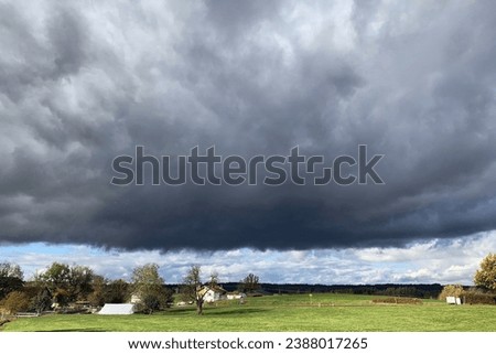 Dramatic sky with raincloud over landscape with lake Royalty-Free Stock Photo #2388017265
