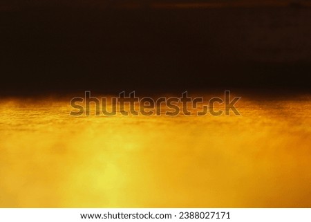 Natural light reflection through yellow glass onto a wooden surface, creating a captivating interplay of light and shadow. Ideal artistic photo for backgrounds.