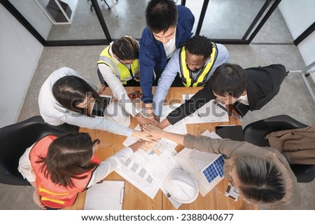 multiracial business partnership doing stacked hands together while meeting in the office for future business cooperation