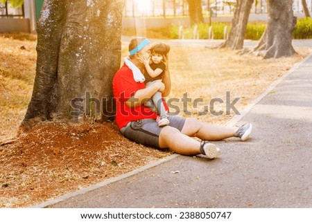Cute picture of overweight father kissing his daughter in the park after morning run