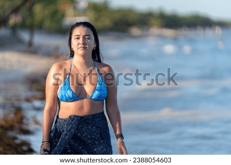 Woman in bikini and sarong enjoying a walk in a caribbean beach
