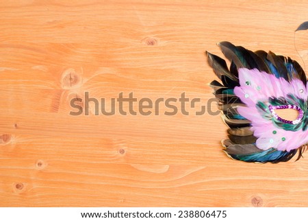 beautiful mask of feathers on a yellow board