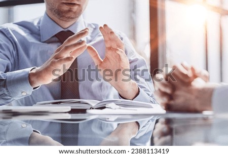 Two business men sit at desk discuss project details sales manager makes commercial offer to company client