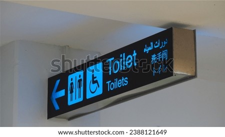 Public restroom signs with a disabled access symbol in airport terminal