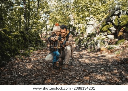 Photographer father and fashionable son happy learning to take photographs in a beautiful natural environment