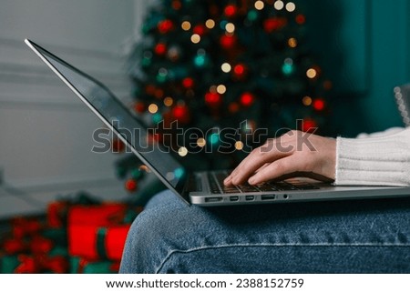 Girl working with a laptop in a Christmas atmosphere.