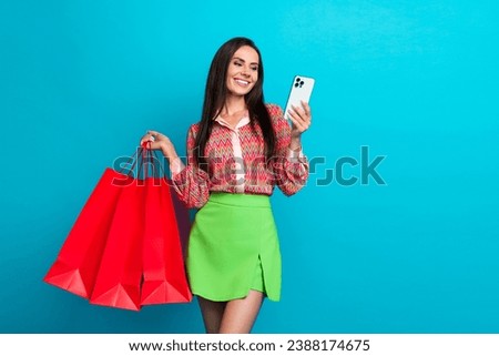 Photo of cheerful young charming woman shopaholic using smartphone to order asos website clothes isolated on aquamarine color background