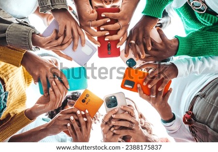 Group of young people using smart mobile phone device outside - Trendy technology concept with guys and girls playing video games app on smartphone - Bright colorful filter Royalty-Free Stock Photo #2388175837