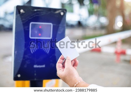 Selective focus to RFID reader with blurry RFID card in hand of driver for automatic barrier gate system. Parking and automatic payment system with licence plate recognition. RFID Concept.