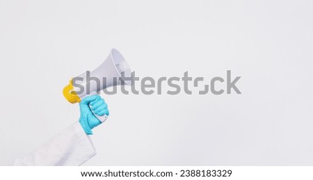 Doctor's hand wear latex glove and hold Megaphone on white background.  Royalty-Free Stock Photo #2388183329