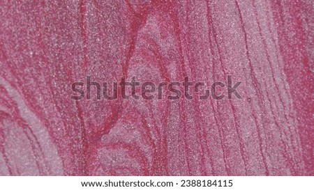 Glitter fluid texture. Paint flow. Gold neon pink white color shiny sparkling metallic ink drip mix motion on defocused art abstract background with copy space.