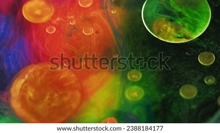 Color ink water. Oil bubble. Galaxy planet. Bright red green blue orange paint mix mist texture drop circles floating on dark black art abstract background.