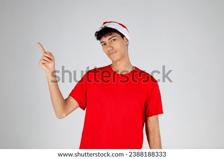 Young Boy with Santa Hat Pointing on White Background. Christmas