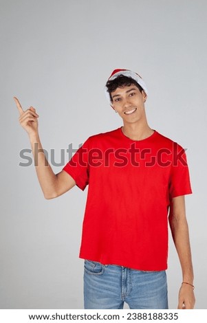 Young Boy with Santa Hat Pointing on White Background. Christmas
