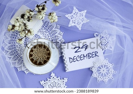 Calendar for December 29: a cup of tea with a decorative snowflake on a lace napkin, the name of the month December in English, numbers 29