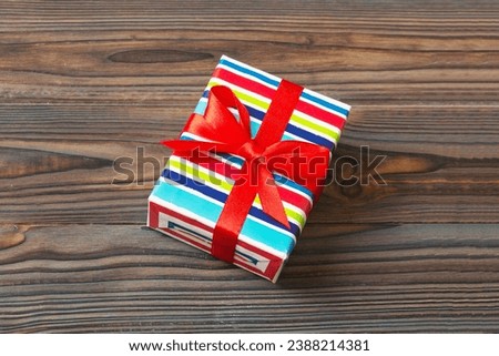 Wrapped christmas or other holiday handmade present in paper with colored ribbon. Present box, decoration of gift on table, top view with copy space.