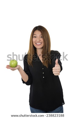 Funny young woman holding an apple while doing a thumb up sign against a white background