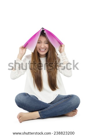 Woman student with notebook on her head against a white background