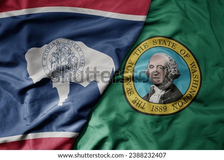 big waving colorful national flag of washington state and flag of wyoming state . macro