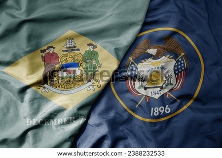 big waving colorful national flag of utah state and flag of delaware state . macro