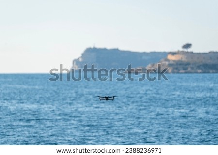Drone flying above blue sea with blurred background