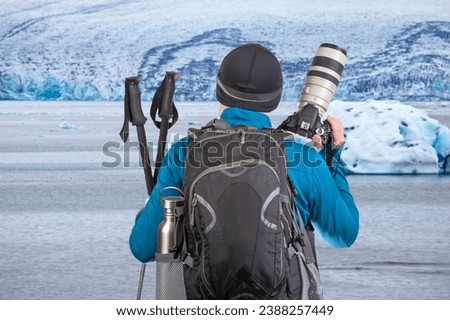 male tourist photographer with a backpack looks at the beauty of nature in the mountains. nature hikes in the mountains