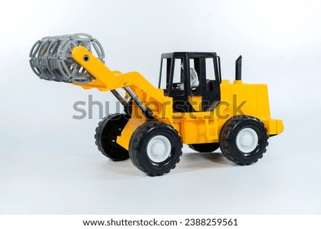 Children's toy Yellow tractor on a white isolated background.Plastic child toy on white backdrop. Construction vehicle. Children's toy. Tractor Toy.