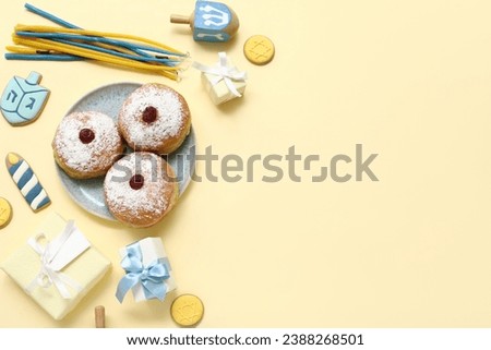 Composition with tasty donuts, gifts and decor for Hanukkah celebration on color background