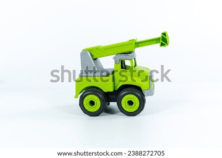 Children's toy green tractor on a white isolated background.Plastic child toy on white backdrop. Construction vehicle. Children's toy. Tractor Toy.