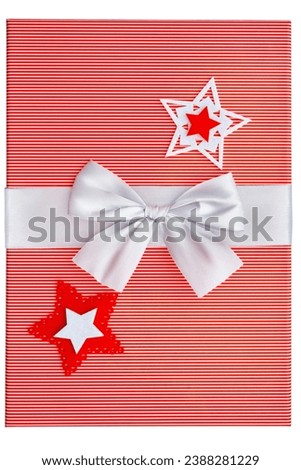 Red striped gift box with a silver bow at the middle.   Holidays card with christmas stars