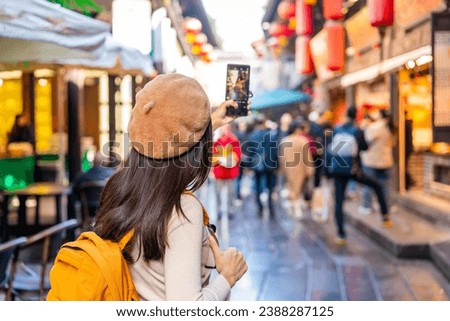 Young female tourist taking a photo of the Jinli Ancient Street in Chengdu, China