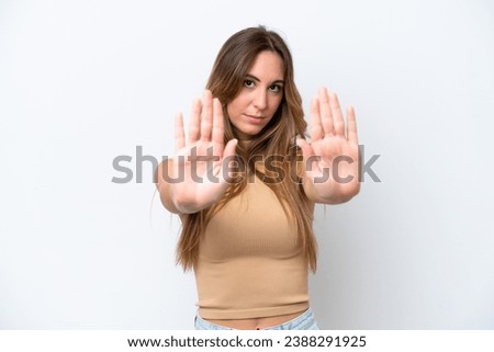 Young caucasian woman isolated on white background making stop gesture and disappointed
