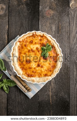 Quiche. Homemade cheese tart  or quiche with cheese, pecorino, bacon and spinach on gray concrete light table background. French Quiche. Top view.