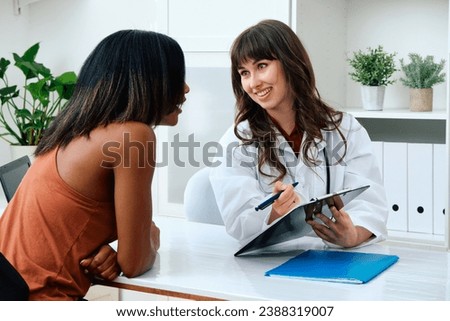 Female doctor filling patient insurance information Royalty-Free Stock Photo #2388319007