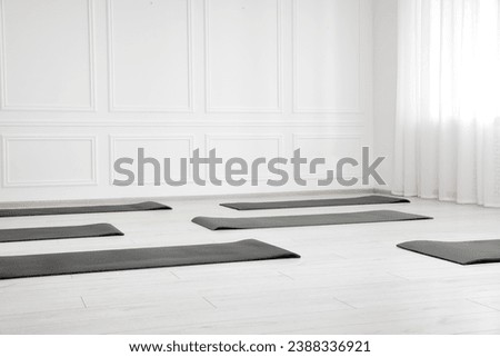 Spacious yoga studio with exercise mats. Space for text