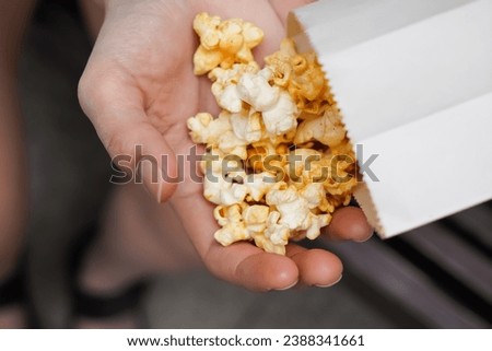 Woman holding popcorn cheese in a paper bag  in the hand