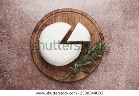 Head of Georgian cheese, Imereti variety, top view, on a cutting board, Royalty-Free Stock Photo #2388344083