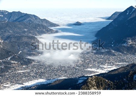 mountain landscape and aerial view of Garmisch-Partenkirchen, Bavaria, Kreuzeck, Germany, fog cloud enters the valley Royalty-Free Stock Photo #2388358959