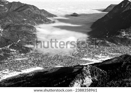mountain landscape and aerial view of Garmisch-Partenkirchen, Bavaria, Kreuzeck, Germany, fog cloud enters the valley Royalty-Free Stock Photo #2388358961