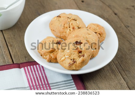 Chocolate chip cookies on white disk on wooden table