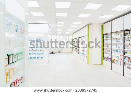 Spacious modern new white drugstore pharmacy chemist`s store with shelves full of medicines, pills, vitamins, painkillers, antibiotics without visitors Royalty-Free Stock Photo #2388372745