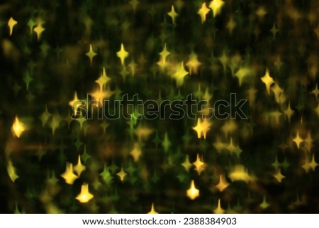 Abstract festive dark background with green and yellow glowing stars