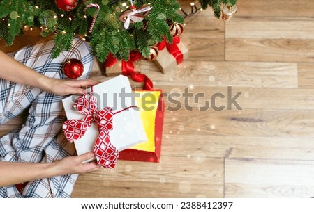 The girl opens a box with a magical Christmas light. Beautiful photo with Christmas gifts, blurred lights, highlights, bokeh, space for a copy. Christmas background, flat layout