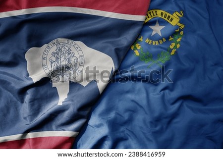 big waving colorful national flag of nevada state and flag of wyoming state . macro