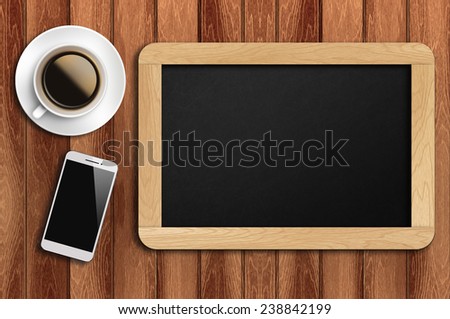 Phone, coffee and blank chalkboard on the table with copyspace area