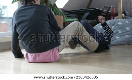 Family Feud Drama - Brothers Locked in Heated Floor Wrestling Royalty-Free Stock Photo #2388426505