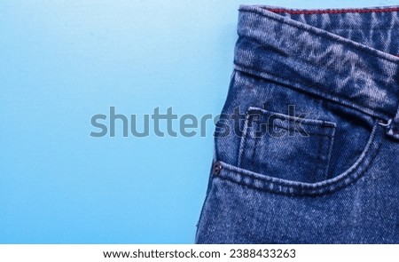 Front pocket of blue denim jeans with prominent stitching. Close up of jeans with lots of pockets