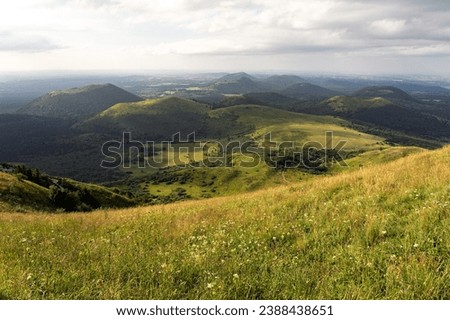 Auvergne vulcan since top of the Puy de Dome vulcan at sunset. Dramatic light landscape. Clermont Ferrand, France. Royalty-Free Stock Photo #2388438651