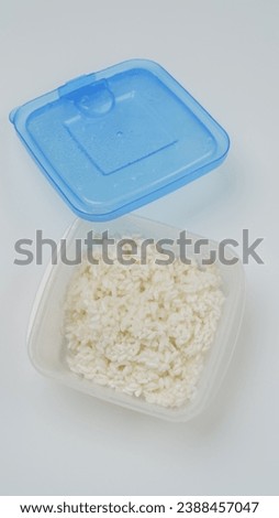 Frozen white rice in a plastic container.